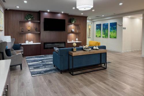 a living room with a blue couch and a tv at Comfort Inn & Suites Concord - Kannapolis in Concord