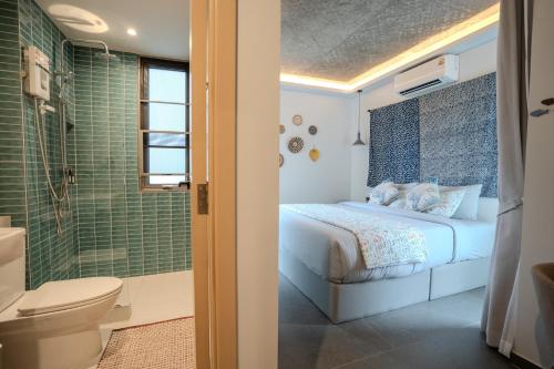 a bedroom with a bed and a shower and a toilet at Ozonizia Family Suites Mai Khao Phuket Yacht Haven in Phuket