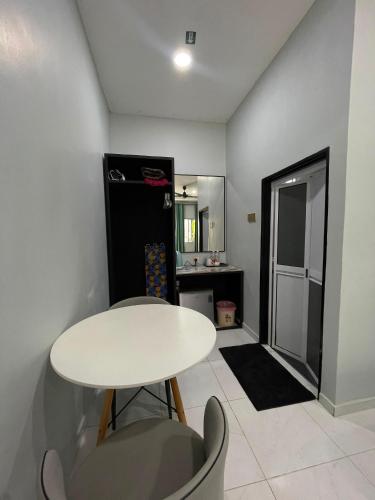 a white table and chairs in a room with a kitchen at Chenang Private Pool Villa & Cottage in Pantai Cenang