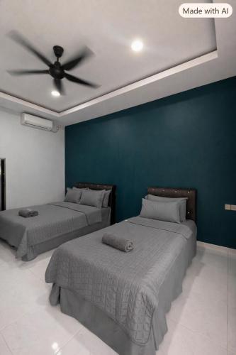two beds in a room with a ceiling fan at Chenang Private Pool Villa & Cottage in Pantai Cenang