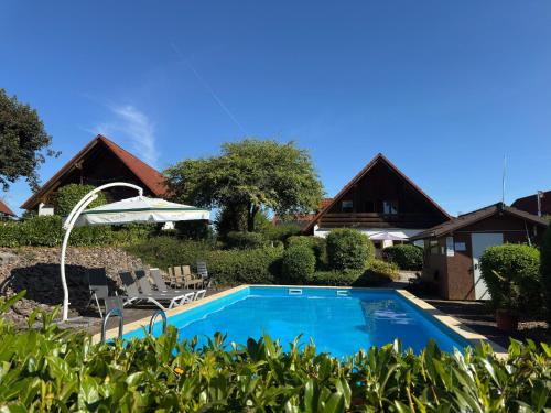 a swimming pool in front of a house at Ferienwohnung mit Loggia im Teutoburger Wald in Bredenborn