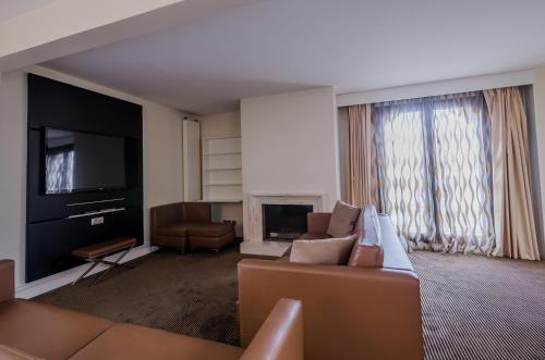 a living room with a couch and a television at Mercure Cergy Pontoise Centre in Cergy