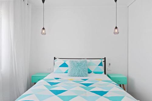 a bedroom with a bed with a blue and white comforter at Casino Views in Apollo Bay