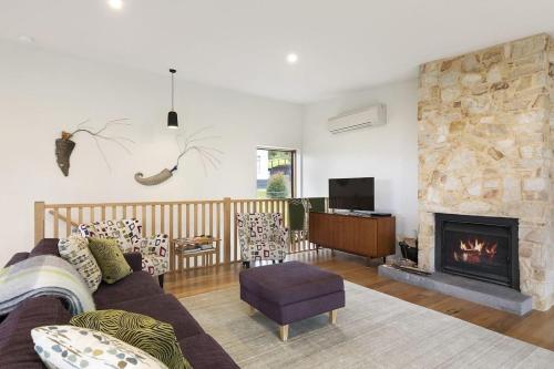 a living room with a couch and a fireplace at Clovelly - BYO Linen in Lorne