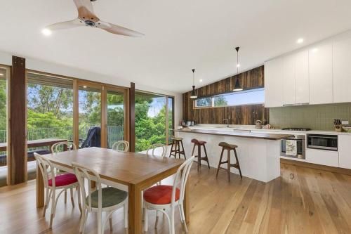 a kitchen with a wooden table and chairs at Clovelly - BYO Linen in Lorne