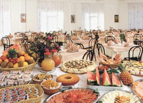 una tabella ricoperta da molti tipi di alimenti diversi di Hotel Sacramora a Rimini
