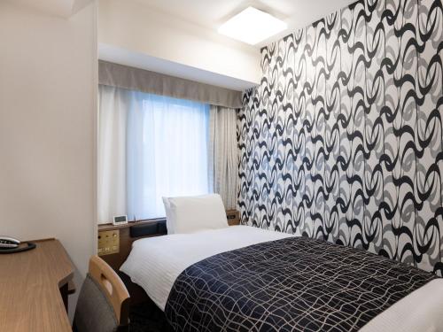 a bedroom with a bed with a black and white patterned wall at APA Hotel Osaka Higobashi Ekimae , All Rooms Non-Smoking in Osaka