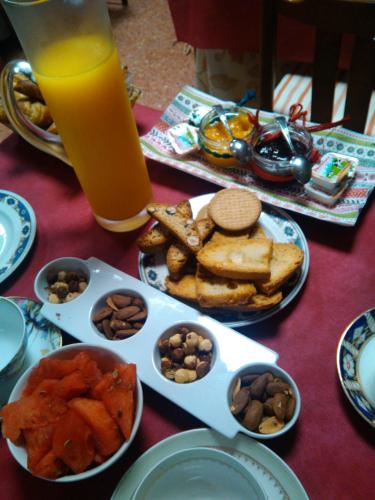 a table topped with plates of food and a glass of orange juice at Hostal Pirineos in Barbastro