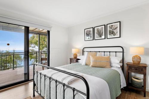 a bedroom with a bed and a balcony at Omaroo in Wye River