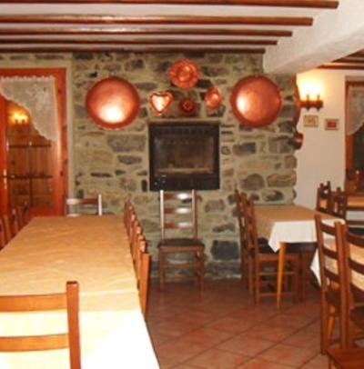 a dining room with a table and chairs and a television at Albergo La Genzianella in Bellagio