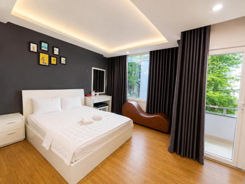 a bedroom with a white bed and a window at LUNA Hotel in Ho Chi Minh City