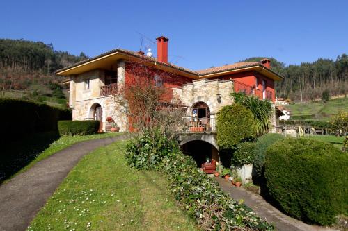 a house on a hill with a road leading to it at Hotel Rural Alavera in San Martin del Mar