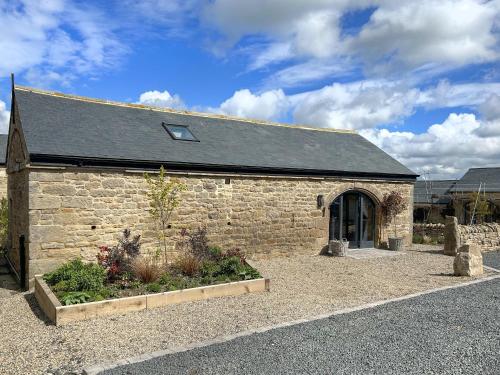 a stone building with a black roof at The Lodge in Consett