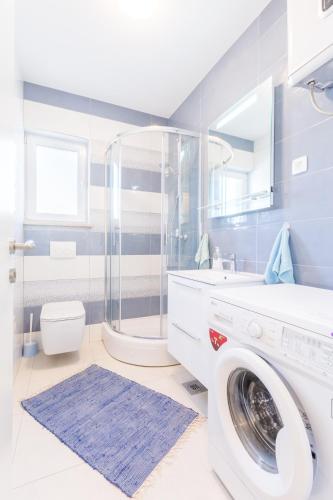 a bathroom with a washing machine and a shower at Mladinic Palace in Milna