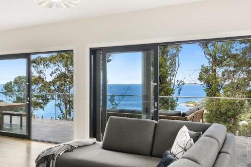 a living room with a couch and large windows at Vue Sur La Mer in Wye River