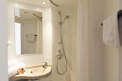 a bathroom with a shower and a sink and a mirror at Résidence Otellia in Blanquefort