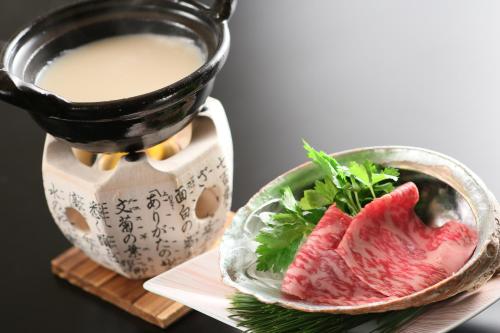 a plate of meat next to a cup of coffee at 旅館かわな -Ryokan Kawana- in Kimitsu