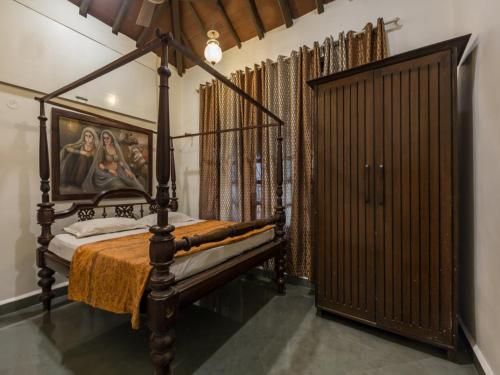 a bedroom with a four poster bed and a gate at SaffronStays Salt Rim on the Beach, Korlai in Christpāda