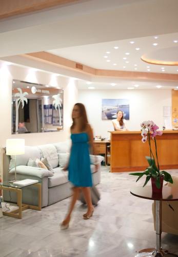 a woman walking through a lobby of a salon at Oasis Scaleta Hotel in Skaleta