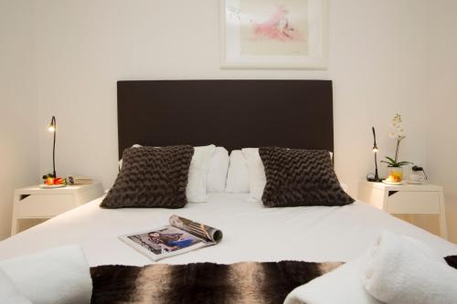 a bedroom with a white bed with a black headboard at El Micalet Apartment in Valencia