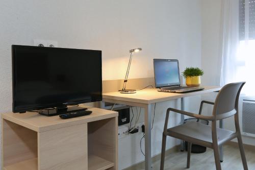 a desk with a computer and a laptop on it at Apparteo Nancy in Nancy
