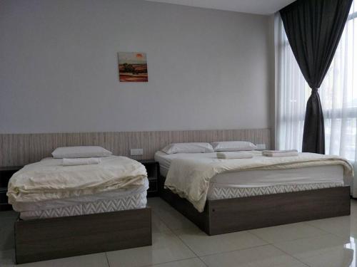two beds sitting next to each other in a room at Lim Mini Hotel in Jementah