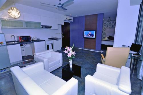 a living room filled with furniture and a tv at Contemporary Heights Hotel and Apartments in Dhaka