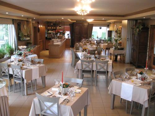 een restaurant met witte tafels en stoelen in een kamer bij Hove Ter Hille in Jabbeke