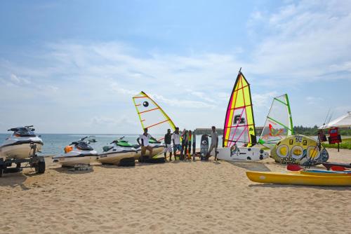 a group of people on a beach with sail boats at Marina Beach Passikudah in Pasikuda