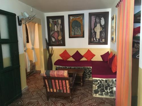 a room with a couch and some pictures on the wall at Chez Eric in Gorée