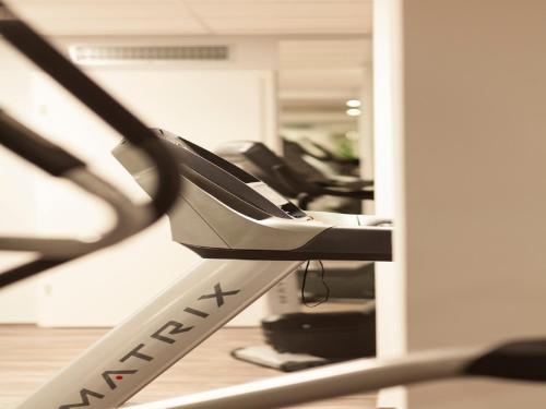 a row of exercise equipment in a gym at Golden Tulip Kassel Hotel Reiss in Kassel