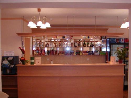 a bar in a restaurant with a counter and lights at Belvárosi Panzió in Debrecen