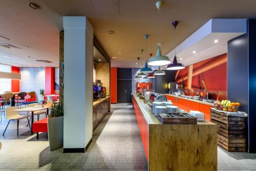 a restaurant with red and blue walls and a counter at ibis Nürnberg City am Plärrer in Nürnberg