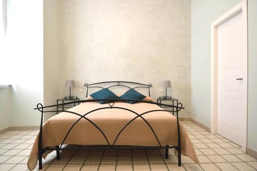 a bedroom with a bed with blue pillows at Residence Stendhal Guest House in Civitavecchia