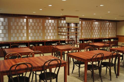 a dining room with wooden tables and chairs at Hotel TAU, Kumamoto in Kumamoto