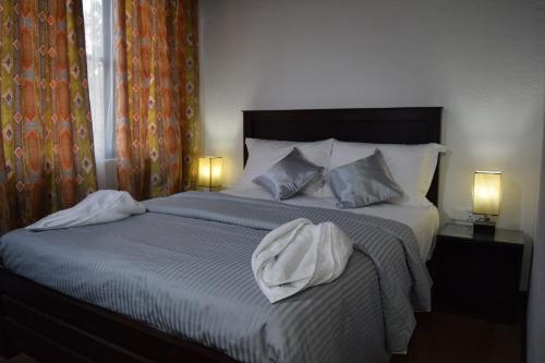a bedroom with a large bed with two lamps at Beraliya Cottage in Nuwara Eliya