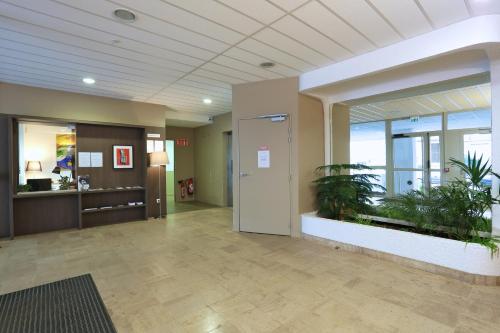 an office lobby with a plant in the middle at Apparteo Nancy in Nancy