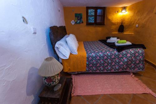 a small bedroom with a bed and a lamp at Talasnal Montanhas de Amor in Lousã