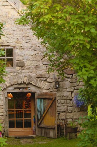 a stone building with a door and a window at Metsara B & B in Tornimäe