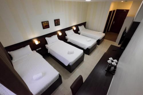 a hotel room with three beds and a couch at Paraiso Verde Hotel in Koronadal
