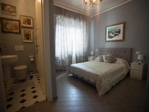 Schlafzimmer mit einem Bett und einem Fenster in der Unterkunft Primavera Apartments in Sanremo