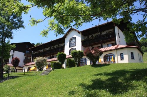 an exterior view of a building with a green lawn at MONDI Resort und Chalet Oberstaufen in Oberstaufen