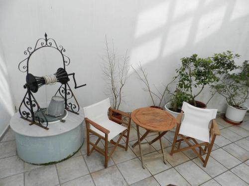a patio with a table and chairs and a camera at En Ermoupoli in Ermoupoli