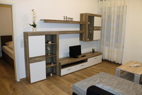 a living room with a book shelf and a tv at Ferienwohnungen Tannenhof in Steinen
