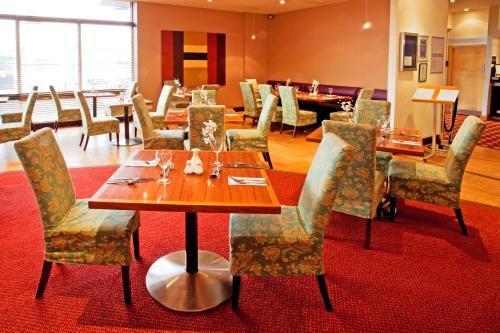 a dining room with tables and chairs in a restaurant at Britannia Hotel Bolton in Bolton