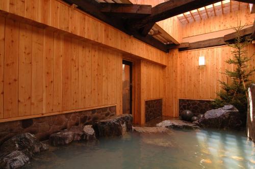 a pool of water in a wooden building at Hotel Gozensui in Akankohan