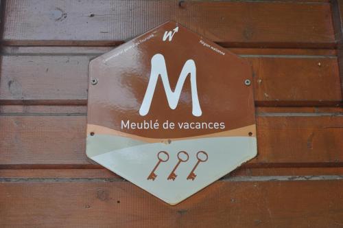 a sign on a wooden wall with the letter m at Chalet Ardenne Mini in Rochehaut