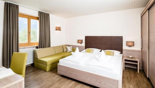 a hotel room with a bed and a couch at Astor Hotel in Schenna