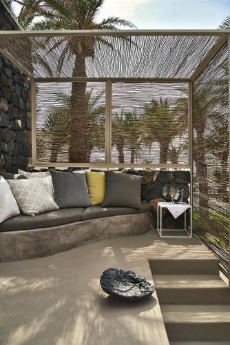 a living room with a couch and a large window at Sikelia Luxury Hotel in Pantelleria