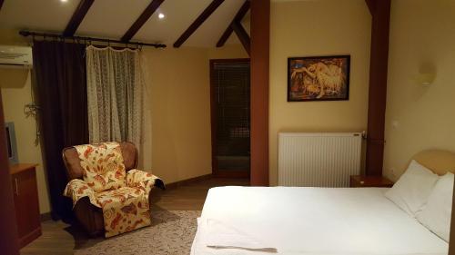 a bedroom with a bed and a chair at Kompleks Fontana in Vladičin Han
